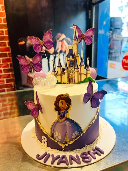 A majestic Sofia the First cake for Jiyanshi's 8th birthday, featuring a castle topper and beautiful purple butterflies.