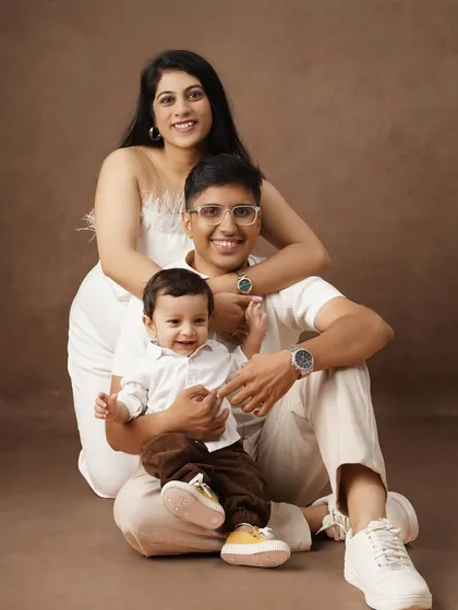 A loving family portrait capturing a candid moment of laughter and connection between two mothers and their baby boy.