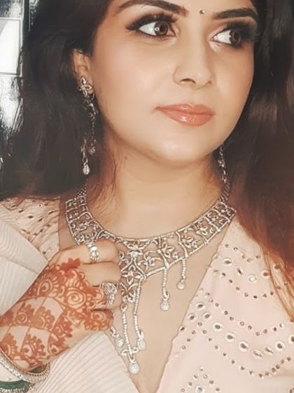 A delicate diamond necklace paired with henna-adorned hands, blending tradition with modern elegance.