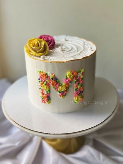 A floral monogram cake, where the initial is beautifully filled with tiny, hand-piped buttercream flowers. This is a wonderful way to personalize a cake.