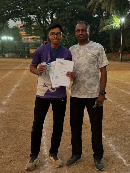 An athlete with his coach after winning silver medals in the 100m and 200m sprints at the SFA championships.