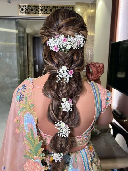 The full back view of the floral pull-through braid, a perfect hairstyle for a spring or summer wedding event.