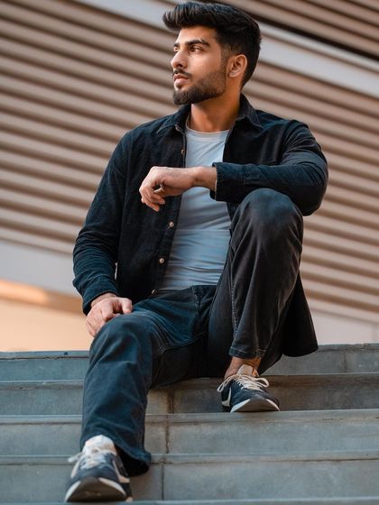 This relaxed, seated pose on the steps showcases a casual, everyday look. It's a great example of a lifestyle-oriented shot that can be used in a model's portfolio to show versatility.