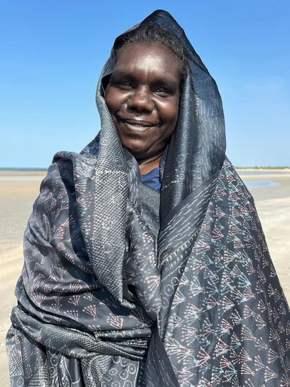 A finished indigo sari from our Bábbarra x Tharangini collaboration, featuring designs by Deborah Wurrkidj and Janet Marawarr. The textile, titled 'Kunred dja Kundalk' (Country and Grasses), blows in the sea breeze at Ndjudda point in Australia.