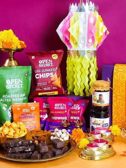 A lavish Open Secret Diwali hamper filled with a variety of healthy snacks and dessert bars. The paper lantern and diyas add a traditional touch to this modern festive gift collection.