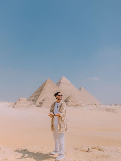 A portrait shot against the clear blue sky and the pyramids. The composition uses negative space to draw attention to both me and the iconic background, creating a clean and powerful travel photo.