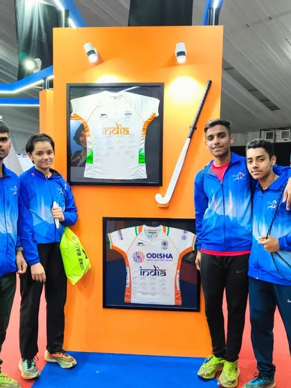Our athletes in their official Trackblazers gear at the Khelo India Youth Games, standing next to a display of the national team's jersey. It's a reminder of the ultimate goal.