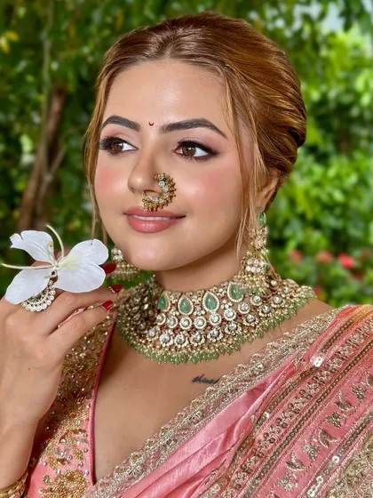 A modern take on the Maharashtrian bridal look. The makeup is minimal and effortless, with peachy tones and luminous skin, perfect for the new-age bride who embraces both heritage and simplicity.