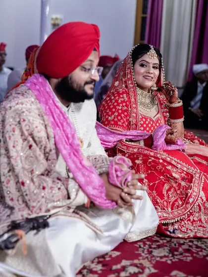 A candid moment between the Sikh bride and groom during their ceremony. The bride's happy glance towards her husband captures a fleeting, genuine emotion that tells a story of their love and comfort with each other.