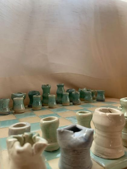 A close-up of the "Cocoa Clash" chess pieces. You can see the charming imperfections and the way the pastel glazes have settled, giving each warrior its own personality.