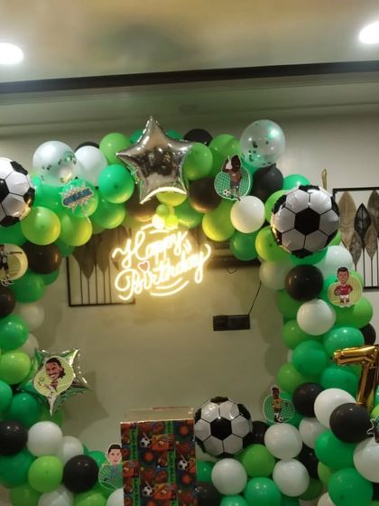 A clear shot of the football-themed balloon arch, decorated with small football cutouts and a star foil balloon.