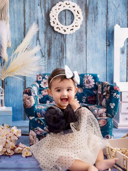 Catching the magic of toddlerhood, this little girl's happy expression is the highlight of this blue-themed portrait.