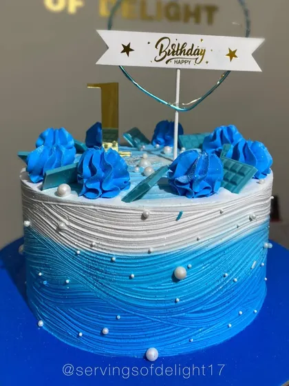 A beautiful blue ombre cake with a textured wave effect. The design is simple, clean, and reminiscent of the ocean.