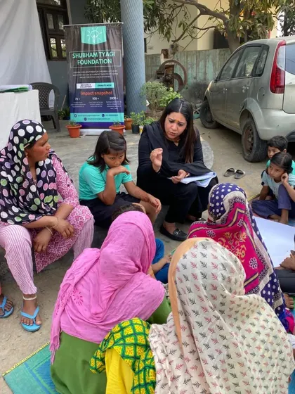 Listening intently to the concerns of women in an informal, ground-level session. Creating a comfortable environment is key to encouraging open dialogue about sensitive issues.
