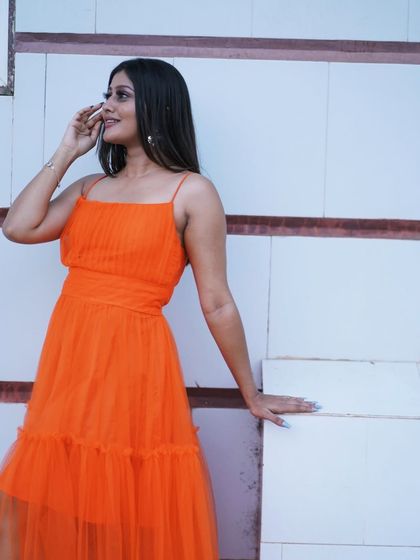 A candid and modern portrait in a simple orange tulle dress. This is a great option for a more casual or fun pre-wedding or personal photoshoot.