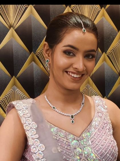 A close-up portrait showing the client's smile and the simple, elegant jewellery she paired with the rental outfit.