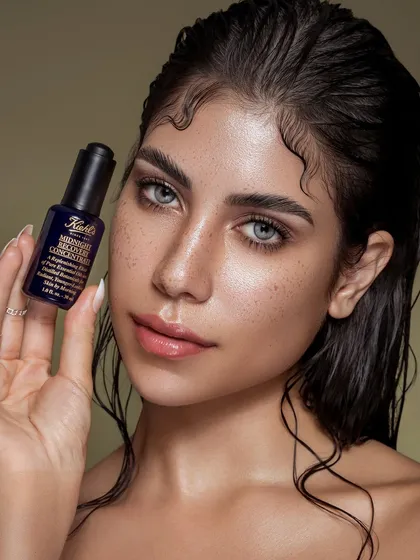 A commercial beauty shot for Kiehl's, balancing product clarity with authentic, dewy skin. The focus is on a healthy, hydrated look that feels attainable, positioning the product as an essential part of a real skincare ritual.