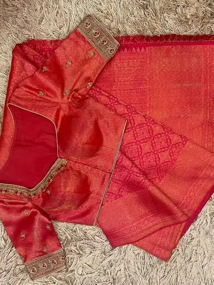 A beautiful pink silk saree paired with a matching pink blouse, featuring delicate gold embroidery on the neckline and sleeves.