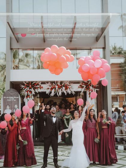 A moment of pure celebration as the bride and groom release balloons with their wedding party outside the church.