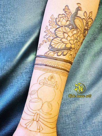 The outline stage of the peacock and kalash design. This shows how we plan the composition before filling in the details.