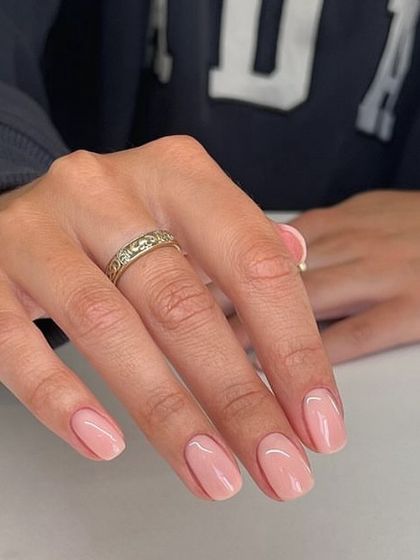 A simple and clean light pink manicure on short, natural nails. This is a perfect example of a classic, well-done gel polish application.