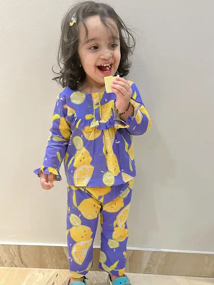 Comfort is key, especially for sleepwear. Here is my daughter enjoying our lemon-print nightwear set, made from butter-soft cotton that is gentle on the skin and ensures a cozy night's sleep for your toddler.