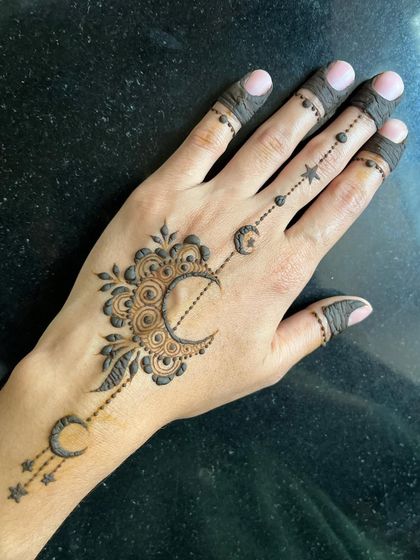 A beautiful Ramadan-themed design with a crescent moon and stars trailing down the hand.
