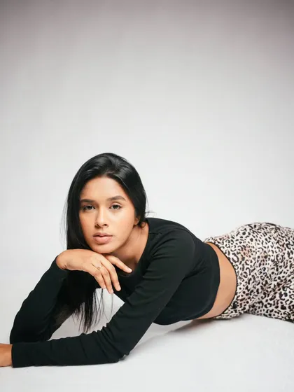 A dynamic lying-down pose that creates interesting lines and a high-fashion feel. The simplicity of the setup keeps the focus on the model.