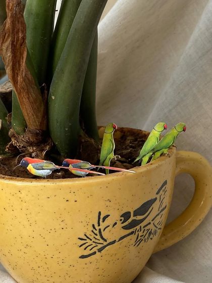 The tiny, hand-applied bird cutouts before they were placed on the invitations. This meticulous detail, featuring parrots and sunbirds, is what makes a design truly bespoke and memorable.