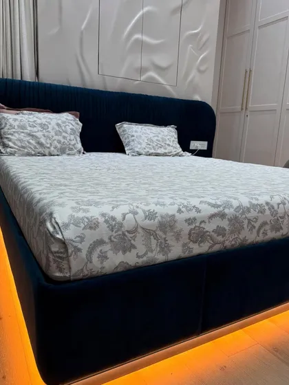 The bed in this room features under-lighting, which creates a beautiful, warm glow and gives the illusion of a floating bed. The headboard is a deep, luxurious blue velvet.