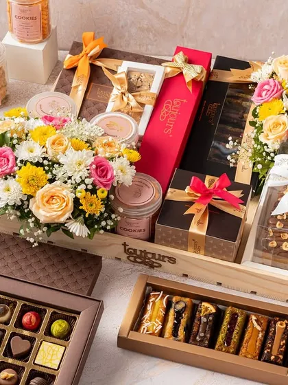 A lavish Diwali hamper showcasing a wide array of my offerings, including artisanal chocolates, financier bars, cookie jars, and fresh flowers, all beautifully arranged in a large wooden crate. This image represents the scale and variety available for corporate and large family gifting.