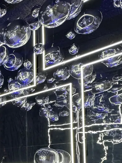 A ceiling of silver disco balls and neon light strips. This installation transformed the entire venue into a futuristic, high-energy dance club.