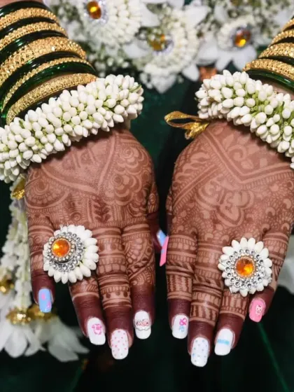 The details matter. This close-up shot from a baby shower highlights the intricate mehndi design and traditional green bangles, capturing the cultural richness of the celebration.
