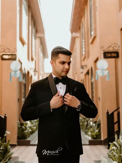 A dapper solo portrait of the groom in his classic black tuxedo, looking sharp and ready for the big moment.