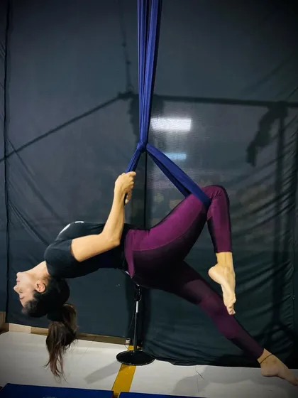 This pose, a variation of a suspended backbend, showcases both strength in the arms and flexibility in the back.