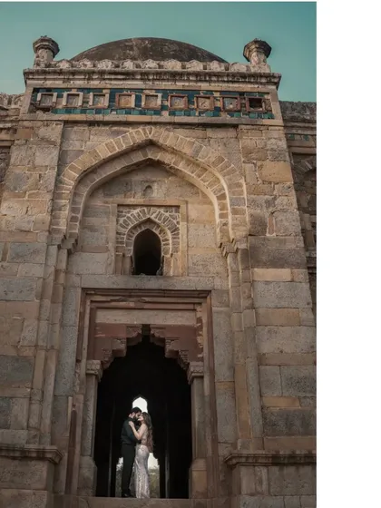 A powerful silhouette of a couple embracing within the grand entrance of a monument. This artistic shot uses the architecture to frame their connection in a dramatic and memorable way.
