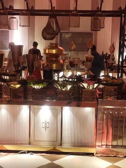 This salad station features an industrial-style overhead structure and rustic hanging elements, adding a unique and stylish touch to the buffet presentation.