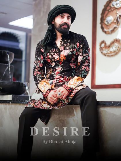 Seated in confidence, wearing a masterpiece. This full-length view shows how my floral and tiger embroidered kurta creates a complete, powerful silhouette. It is designed to make an impact from every angle.