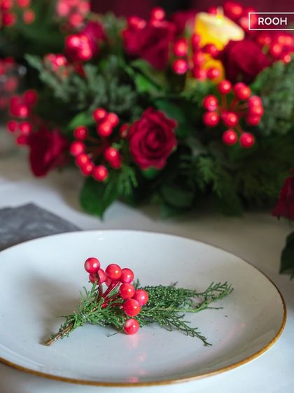 Taste the magic of Christmas with this simple, elegant detail. A sprig of holly on a plate is a small touch that signals the start of a festive meal.