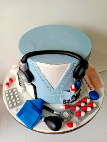 A top-down view of the doctor-themed cake, showing all the meticulously handcrafted medical tools. The details, like the pills in the pocket and the texture of the scrubs, are what bring this cake to life.