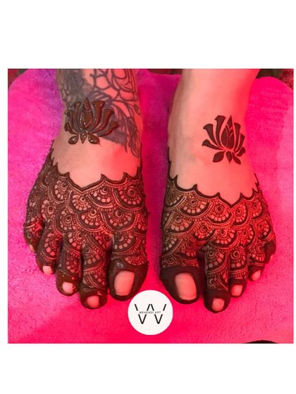 Bridal feet adorned with delicate lotus motifs and scalloped patterns. This design ensures a complete and stunning bridal look.