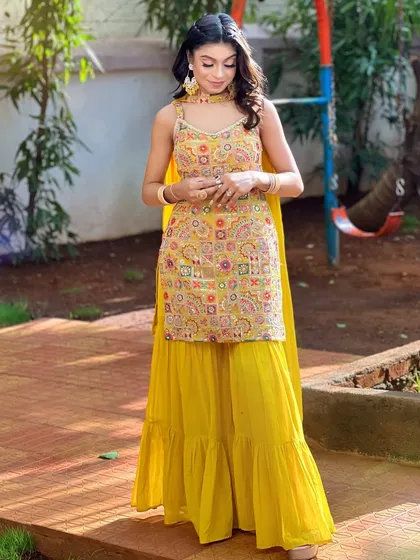 A full-length shot of a vibrant Haldi look in a yellow sharara, created during my airbrush seminar.