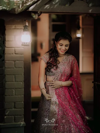 The bride-to-be in her beautiful pink lehenga, her smile lighting up the room as she enters the celebration.