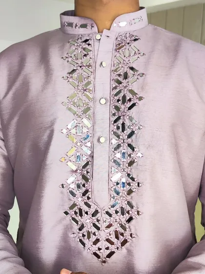 A detailed shot of the original mirror-cut embroidery on a lavender kurta. This traditional craft adds a brilliant sparkle and is a popular choice for festive and sangeet outfits.