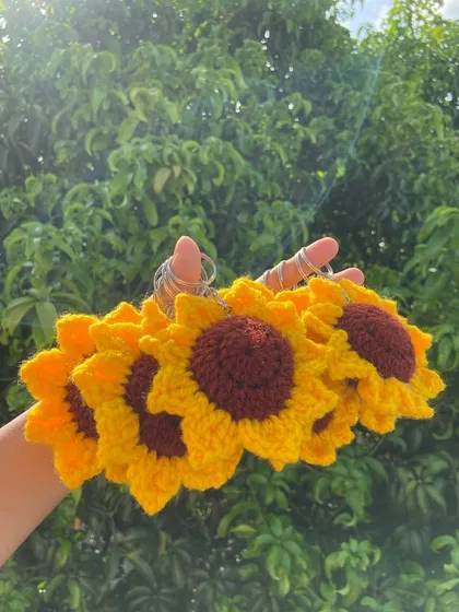 A handful of my signature sunflower keychains, with the sun shining through. They are one of my most requested items for bulk orders.