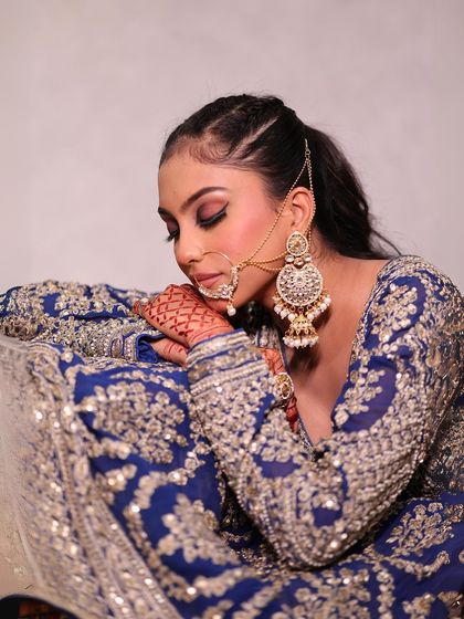 A soft, artistic shot focusing on the henna and the rich texture of the lehenga.