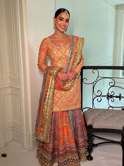 Glam queen with a nude sheen. This look, paired with a colorful Mayyur Girotra outfit, is perfect for a fun and festive mehendi ceremony.