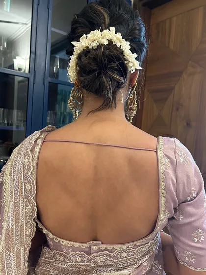 A back view of the classic gajra bun, showing the clean lines and beautiful placement of the flowers. This hairstyle is perfect for showcasing a low-back blouse.