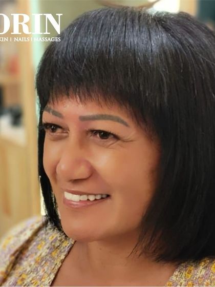 A happy client showing off her sleek new bob. The style is polished and gives her a confident, modern look.