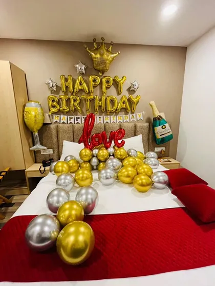 A royal-themed birthday decoration in gold and silver. This setup includes a crown foil balloon, champagne bottle and glass balloons, and a "love" sign to celebrate your king or queen.